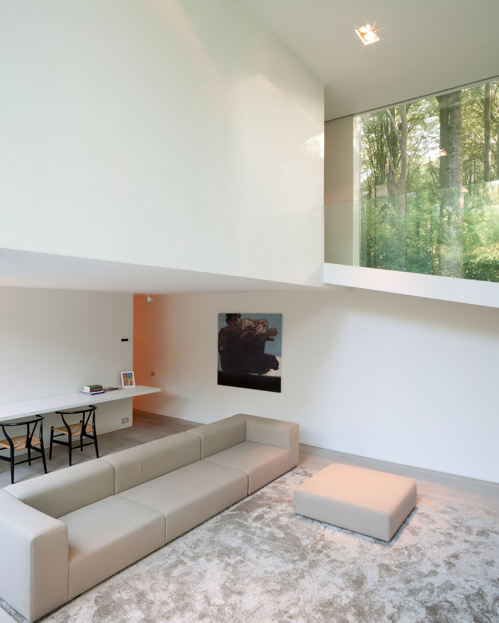 Na úrovni mezi ložnicí v dolním patře a dětským pokojem v horním patře se nachází prostorný obývací pokoj se zvýšeným stropem.